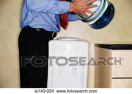 Picture - Man changing water container. Fotosearch