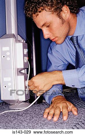 Stock Photo - Man putting lead in socket. Fotosearch