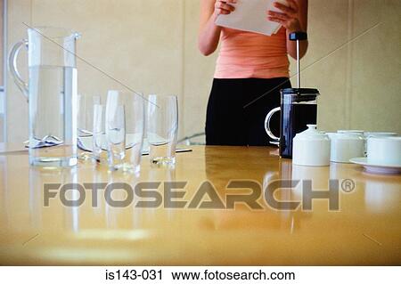 Woman prepares meeting table View Large Photo Image Stock Image - Woman prepares meeting table. Fotosearch