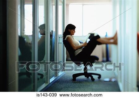 Woman puts feet up at work View Large Photo Image Stock Photo - Woman puts feet up at work. Fotosearch