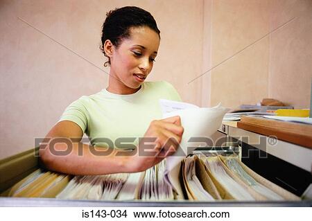 Picture - Woman using the filing cabinet. Fotosearch