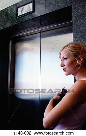 Woman waiting by the lift door View Large Photo Image Stock Image - Woman waiting by the lift door. Fotosearch