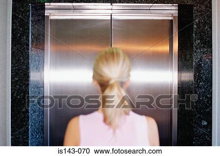 Woman waits in front of lift View Large Photo Image Stock Image - Woman waits in front of lift. Fotosearch