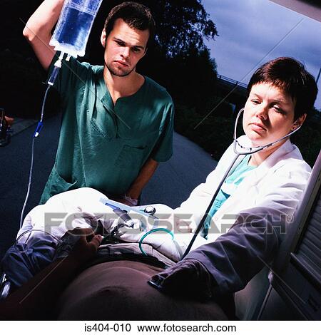 Stock Image - Ambulance staff with patient. Fotosearch