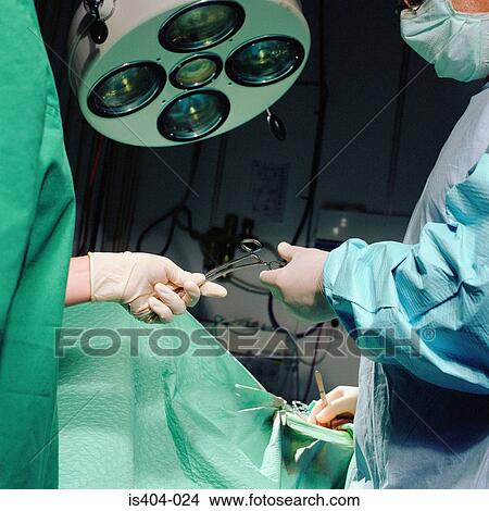 Nurse handing sterile tools View Large Photo Image Picture - Nurse handing sterile tools. Fotosearch