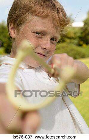Boy aiming catapult at camera View Large Photo Image Stock Photo - Boy aiming catapult at camera. Fotosearch