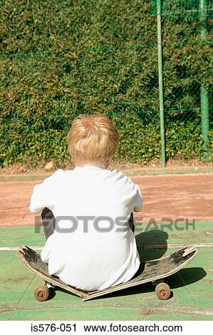 Stock Image - Boy on broken skateboard. Fotosearch