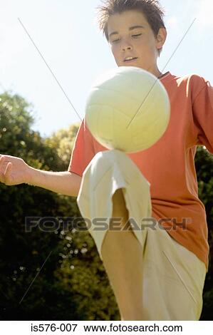 Stock Photo - Boy playing with football. Fotosearch