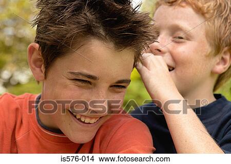 Picture - Boy whispering to friend. Fotosearch