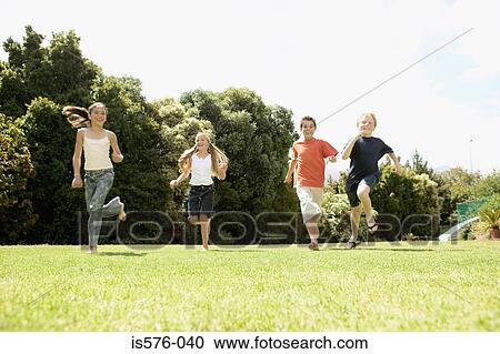 Stock Image - Children running on the grass. Fotosearch
