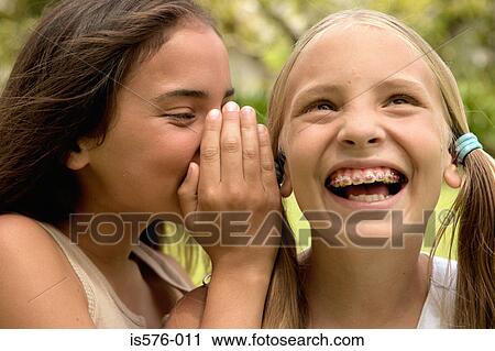 Girl whispering to friend View Large Photo Image Stock Image - Girl whispering to friend. Fotosearch