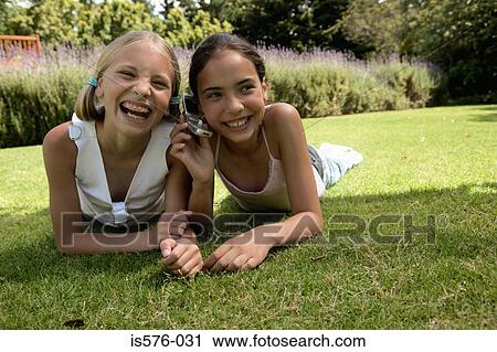 Stock Image - Happy girls and mobile phone. Fotosearch