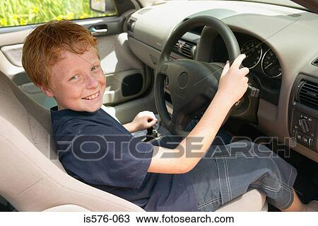 Smiling boy at wheel of car View Large Photo Image Stock Image - Smiling boy at wheel of car. Fotosearch