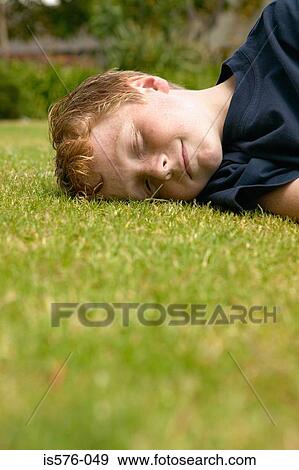 Smiling boy lying on the grass View Large Photo Image Stock Photo - Smiling boy lying on the grass. Fotosearch