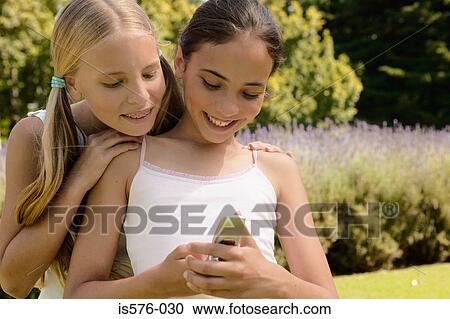 Two girls with mobile phone View Large Photo Image Stock Image - Two girls with mobile phone. Fotosearch
