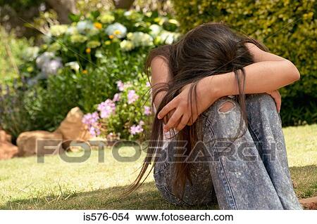 Picture - Unhappy young girl outdoors. Fotosearch