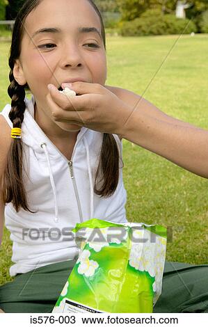 Young girl eating popcorn View Large Photo Image Stock Image - Young girl eating popcorn. Fotosearch