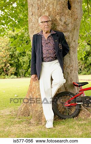 Stock Photograph - Older man in garden & bicycle. Fotosearch