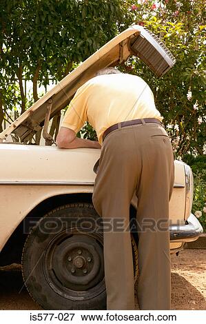 Older man looks at car engine View Large Photo Image Stock Photo - Older man looks at car engine. Fotosearch