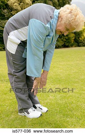 Stock Photograph - Older woman stretches outside. Fotosearch