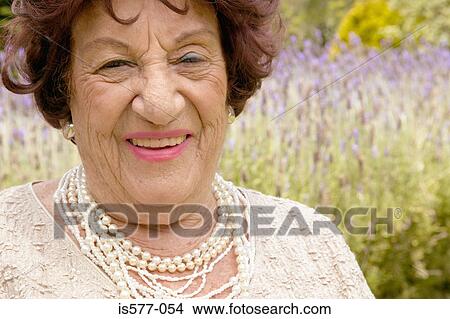 Smiling older woman in garden View Large Photo Image Picture - Smiling older woman in garden. Fotosearch