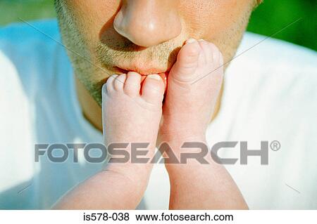 Stock Photo - Dad kissing baby's feet. Fotosearch