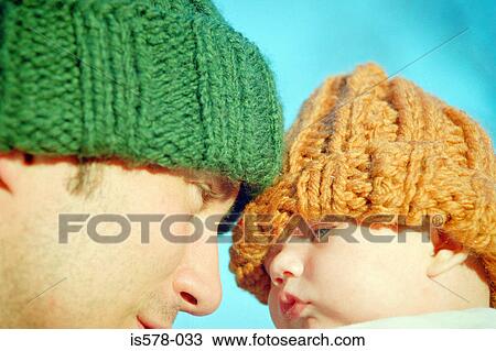 Stock Image - Dad with baby in woolie hats. Fotosearch