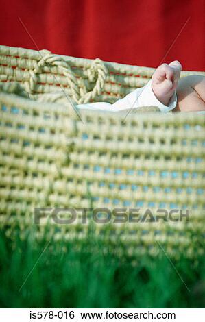 Stock Photograph - Straw baby carrier on grass. Fotosearch