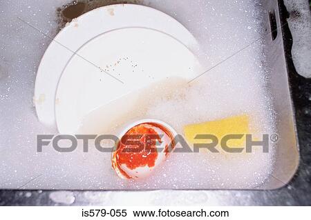 Stock Photography - Dishes soaking in soapy water. Fotosearch