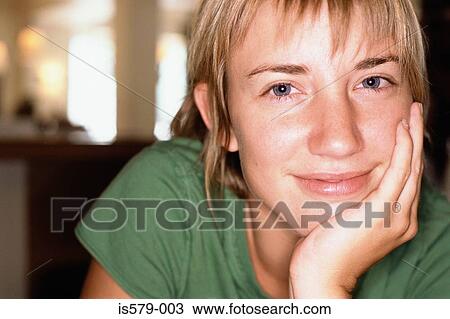 Stock Image - Smiling young woman in cafe. Fotosearch