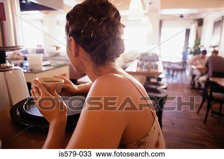 Stock Image - Young woman having coffee. Fotosearch