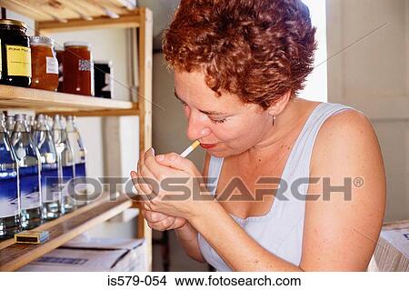 Young woman lights cigarette View Large Photo Image Picture - Young woman lights cigarette. Fotosearch
