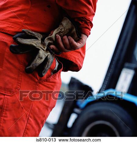 Stock Image - Construction worker holding gloves. Fotosearch