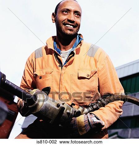 Stock Image - Construction worker using pneumatic drill. Fotosearch