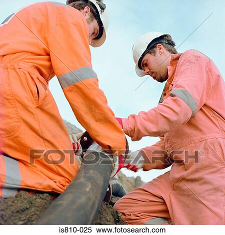 Construction workers holding a pipe View Large Photo Image Stock Photography - Construction workers holding a pipe. Fotosearch