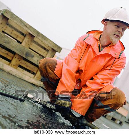 Stock Image - Engineer holding pipe. Fotosearch