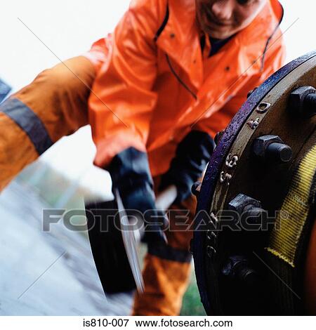 Stock Photo - Engineer using a mallet. Fotosearch