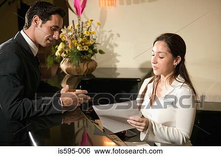 Stock Photograph - Businessman at hotel reception. Fotosearch