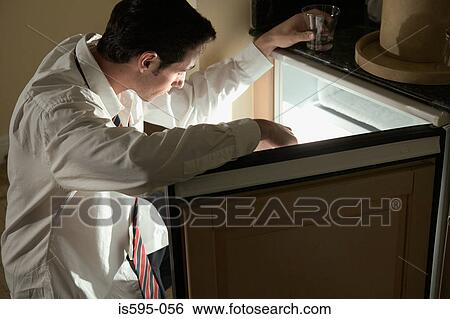 Businessman looking in refrigerator View Large Photo Image Stock Photograph - Businessman looking in refrigerator. Fotosearch