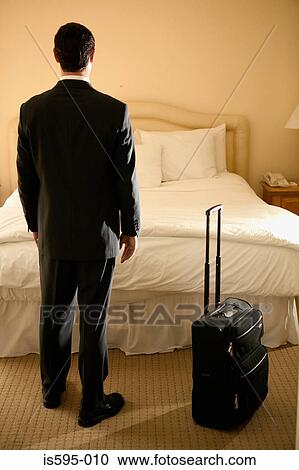 Businessman standing in hotel room View Large Photo Image Stock Image - Businessman standing in hotel room. Fotosearch