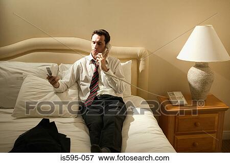 Stock Photo - Businessman using telephones. Fotosearch