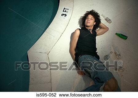Man lying by swimming pool View Large Photo Image Stock Image - Man lying by swimming pool. Fotosearch