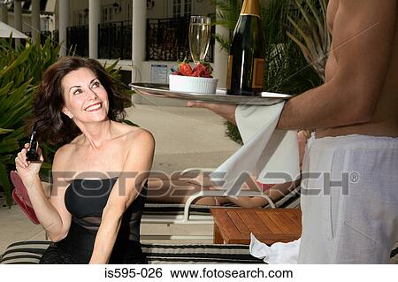 Woman smiling at young waiter View Large Photo Image Stock Photograph - Woman smiling at young waiter. Fotosearch