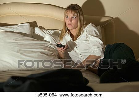 Woman watching television in hotel room View Large Photo Image Picture - Woman watching television in hotel room. Fotosearch