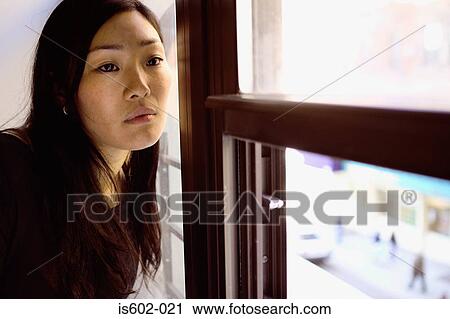 Asian woman sitting near window View Large Photo Image Stock Image - Asian woman sitting near window. Fotosearch