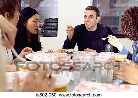 Friends eating fast food at table View Large Photo Image Stock Image - Friends eating fast food at table. Fotosearch
