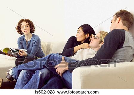 Friends relaxing on sofa View Large Photo Image Stock Photo - Friends relaxing on sofa. Fotosearch