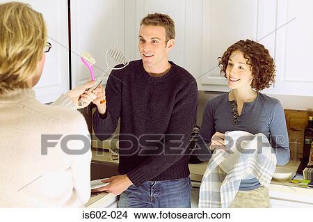 Friends standing in kitchen View Large Photo Image Picture - Friends standing in kitchen. Fotosearch