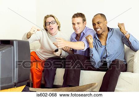 Friends watching television on sofa View Large Photo Image Stock Photo - Friends watching television on sofa. Fotosearch