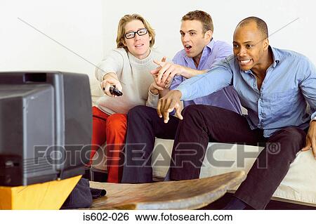 Friends watching television on sofa View Large Photo Image Stock Photograph - Friends watching television on sofa. Fotosearch